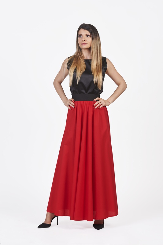 A woman wearing a long red skirt, exuding elegance and sophistication.
