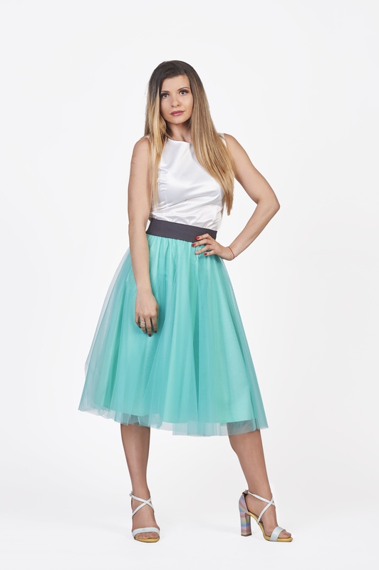 An elegant play of light and shadows comes alive in the midi mint tulle skirt, a mesmerizing fusion of style and allure.